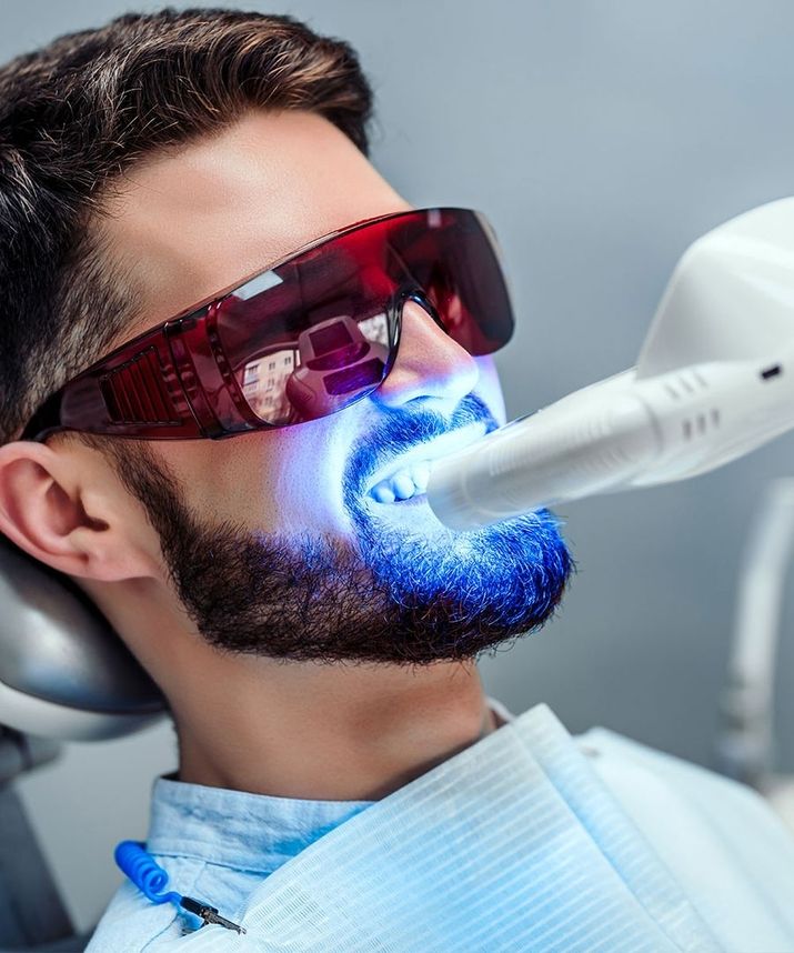 Mann mit einer UV Lampe vor dem Gesicht